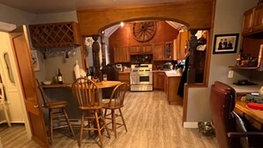 A kitchen with wooden cabinets, a dining area with chairs, and a central island. - Near The Baseball Hall of Fame, Glimmerglass Opera and Dream Park Baseball Camp (Cherry Valley)
