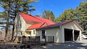 A two-story house with a red roof, a garage, and a front porch. - Near The Baseball Hall of Fame, Glimmerglass Opera and Dream Park Baseball Camp (Cherry Valley)