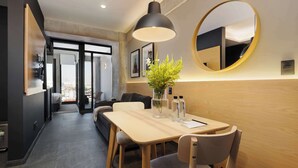 Une chambre d’hôtel moderne dotée d’un coin repas, d’un grand miroir et offrant une vue sur la ville.
