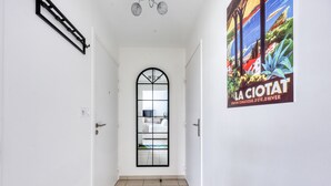 A narrow hallway with a white door, a black-framed window, and a poster on the wall. - La Terrasse de La Ciotat - climatisé, proche plage (La Ciotat)
