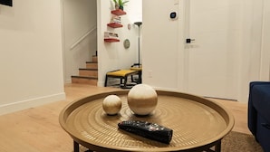 A living room with a round coffee table, two decorative spheres, and a remote control.