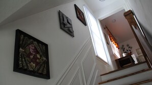 A staircase with white walls and a framed floral painting. - Cozy House located close Skylon Towery, Falls view Casino & Horseshoe Falls (Niagara Falls)