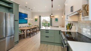 Una cucina moderna con una grande isola, elettrodomestici in acciaio inossidabile e un'area pranzo con vista.
