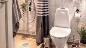 Un bagno moderno con doccia, servizi igienici e porta asciugamani.