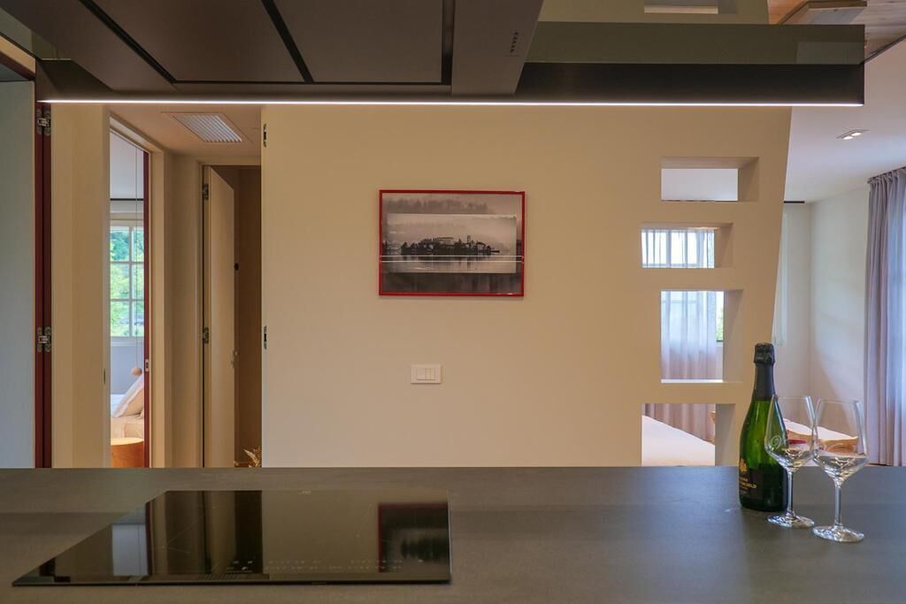 A modern interior with a flat-screen TV, a framed picture on the wall, and a bottle of champagne on a table.