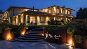 A luxury villa with a well-lit entrance, a landscaped garden, and a sign reading 'Villa Amelia Luxury Living.' - Villa Amelia (Orta San Giulio)