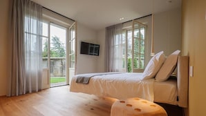 Un dormitorio con cama, televisión y un ventanal grande.