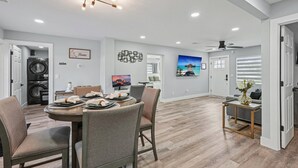 Una cocina moderna con comedor, lavadora y un cuadro en la pared.