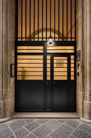 A black double door with a small plaque and a sign reading 'CASA NOVA.' - La Casetta di Gelsomina | Centro Storico | 4 pax (Napoli)