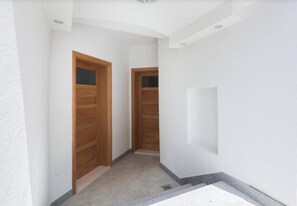 A narrow hallway with wooden doors and a white wall. - A1 - cozy studio in the heart of Split with parking (Split)