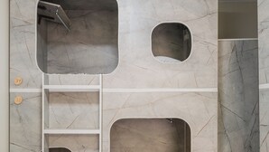 Habitación con unidad de almacenamiento empotrada que incluye varios compartimentos y una escalera.