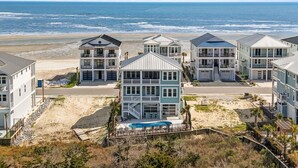 A beachfront property with multiple-story buildings, a swimming pool, and a view of the ocean. - Into The Mistic, Ocean Isle Beach (Ocean Isle Beach)