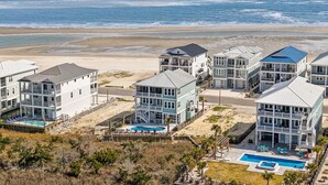 A coastal hotel with multiple buildings, a swimming pool, and a beach view. - Into The Mistic, Ocean Isle Beach (Ocean Isle Beach)