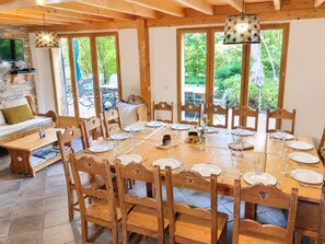 A dining area with a wooden table set for six, surrounded by wooden chairs with heart-shaped cutouts. - GITES LE MOULIN - LA COMPOTE (LA COMPOTE)