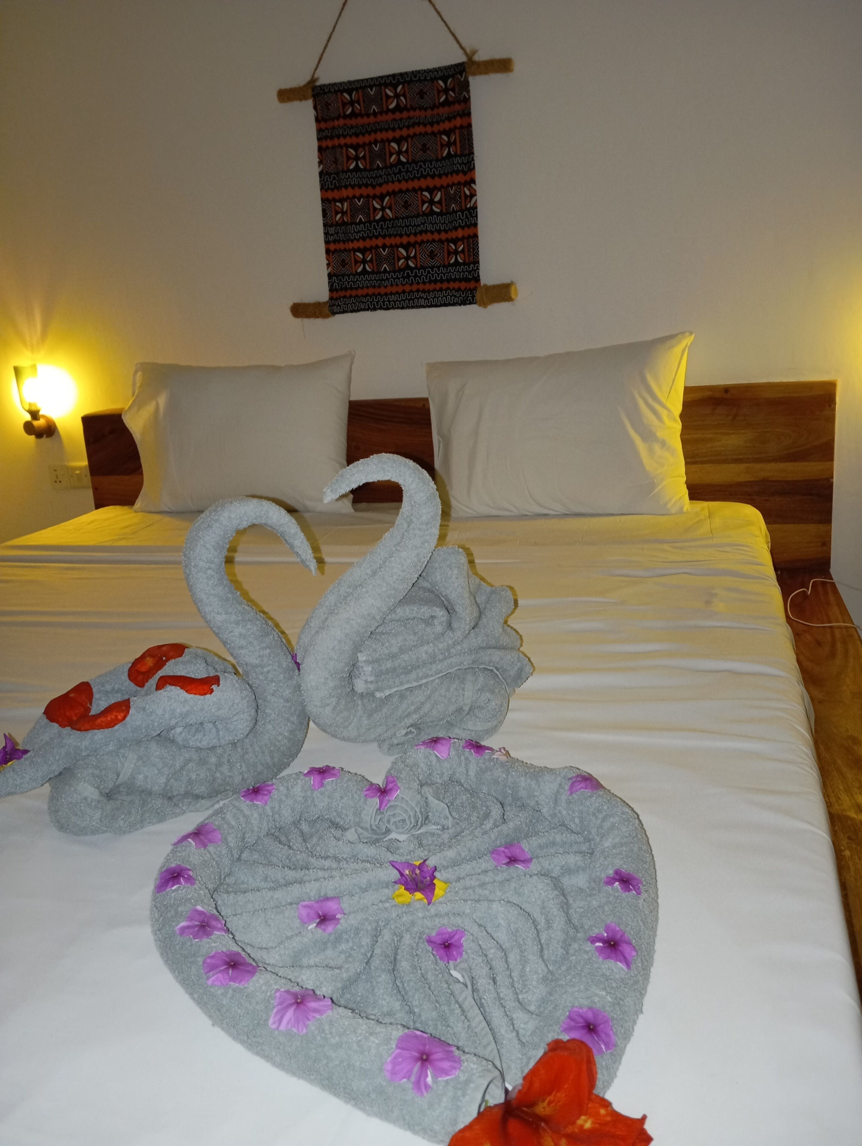 A bed with a decorative swan design and a wall hanging above it.