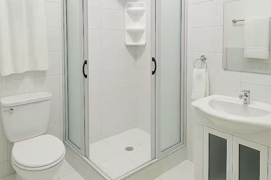 Een douche, handdoeken, zeep, toiletpapier