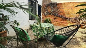 Une terrasse avec une table, des chaises et un hamac.