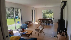 A spacious living area with a dining table, chairs, a sofa, and a fireplace. - Peace and quiet in the Pays d'Oust and Brocéliande regions (Montertelot)