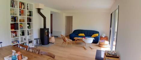 A living room with a bookshelf, a sofa, a table, and a fireplace.