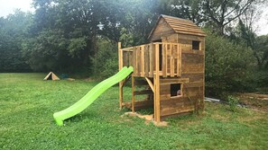A wooden playhouse with a slide in a grassy yard. - Peace and quiet in the Pays d'Oust and Brocéliande regions (Montertelot)