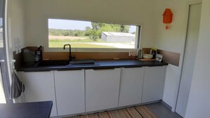 A compact kitchen with a window, a sink, a kettle, and a small refrigerator. - Peace and quiet in the Pays d'Oust and Brocéliande regions (Montertelot)