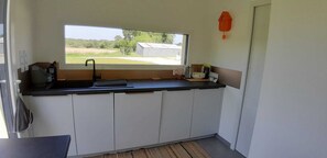 A compact kitchen with a window, a sink, a kettle, and a small refrigerator. - Peace and quiet in the Pays d'Oust and Brocéliande regions (Montertelot)