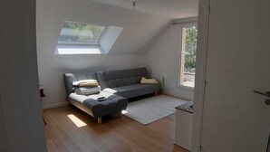 A room with a loft bed, a grey sofa, a small rug, and a skylight. - Peace and quiet in the Pays d'Oust and Brocéliande regions (Montertelot)