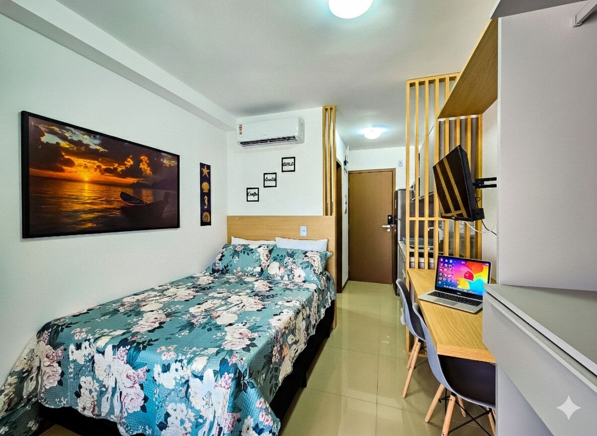 Un dormitorio con una cama, un escritorio con una computadora portátil, un televisor y un aire acondicionado de pared.