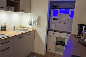 A modern kitchen with a sink, cabinets, and a countertop.