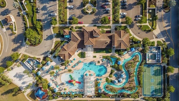 An aerial view of a resort with a swimming pool, a basketball court, and a bridge over a body of water. - Resort Home, Private Pool and Spa, Outdoor Theater (Kissimmee)