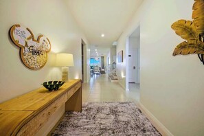 A hallway with a wooden console table, a wall-mounted bulletin board, and a large decorative leaf. - Windsor Resort, Private Pool & Theater, Game Room (Davenport)