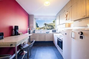 Eine moderne Küche mit Essbereich, einem großen Fenster und Blick ins Freie.