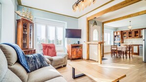 A living room with a sofa, a coffee table, a TV, and a wooden cabinet. - Spacieuse résidence de famille cadre privilégié (Loctudy)