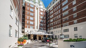 A multi-story hotel with a prominent entrance, brick facade, and a clear sky. - Nell Gwynn House Apartments & Rooms (London)