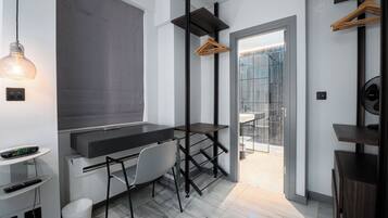A modern room with a desk, chair, and a hanging light fixture.