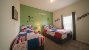 Quarto com duas camas, parede decorada com tema de beisebol e janela com cortinas.