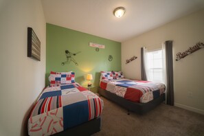Ein Schlafzimmer mit zwei Betten, einer Wand im Baseball-Design und einem Fenster mit Vorhängen.