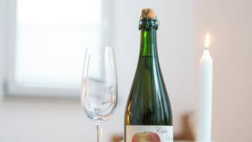 Una mesa con una botella, una vela y un vaso.