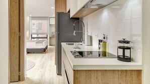 A modern kitchen with a built-in stove, a sink, and a coffee maker. - w* | Soft Light Loft in the Heart of Bogotá (Bogotá)