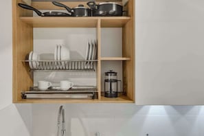 A kitchen with wooden shelves, a coffee maker, and utensils. - w* | Signature Loft in the Heart of Bogotá (Bogotá)