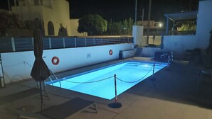 En utomhuspool med en livboj, en hoppställning och en kedjebom.