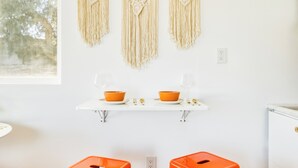 A kitchen with a white countertop, two orange bowls, and a macrame wall hanging. - 10 Mins To Joshua Tree National Park & Marine Base. Fire Pit, Romantic Retreat (Twentynine Palms)