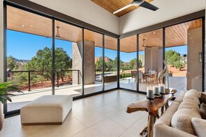 A spacious room with large windows, a wooden ceiling, and a view of the outdoors. - Luxury NEW home Built 2024-Pool-Sedona Red Rock Views (Sedona)