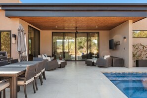 An outdoor patio with a pool, wicker furniture, and a ceiling fan. - Luxury NEW home Built 2024-Pool-Sedona Red Rock Views (Sedona)