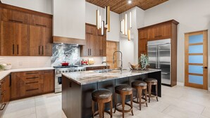 A modern kitchen with wooden cabinets, a marble island, stainless steel appliances, and pendant lighting. - Luxury NEW home Built 2024-Pool-Sedona Red Rock Views (Sedona)