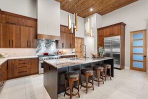 A modern kitchen with wooden cabinets, a marble island, stainless steel appliances, and pendant lighting. - Luxury NEW home Built 2024-Pool-Sedona Red Rock Views (Sedona)
