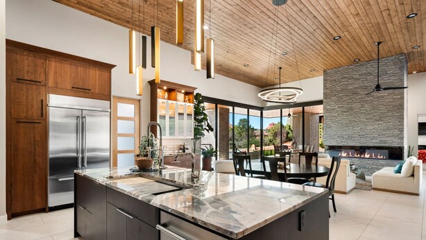A modern kitchen with a large island, stainless steel appliances, and a dining area with a fireplace. - Luxury NEW home Built 2024-Pool-Sedona Red Rock Views (Sedona)