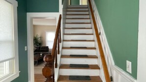 A staircase with wooden steps and a wooden handrail, leading to an upper floor. - Green Mountain Retreat (Rutland)