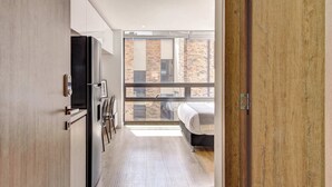 Una cocina moderna con refrigerador, armarios y ventana con vista a un edificio de ladrillo.