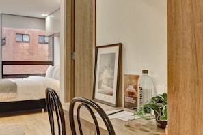 Ein Hotelzimmer mit einem Bett, einem gerahmten Bild, einer Flasche und einer Pflanze.